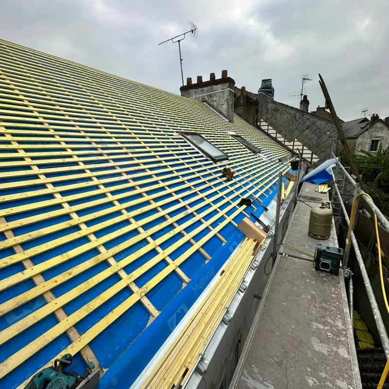 Toiture mise à nu, liteaux et écran de sous-toiture posés, avant la couverture en ardoise