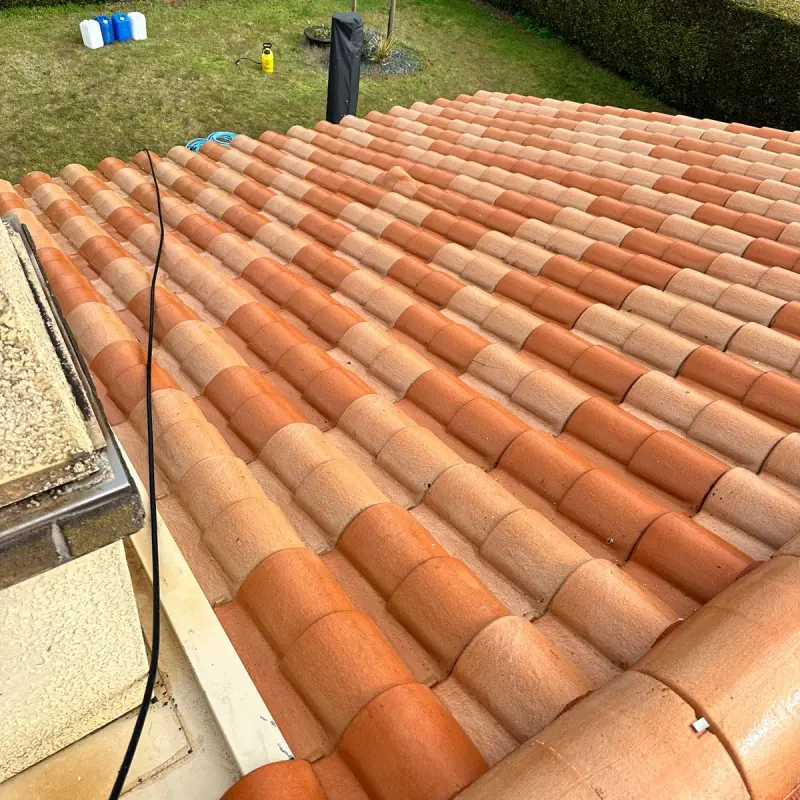 La même toiture en tuiles après démoussage et traitement