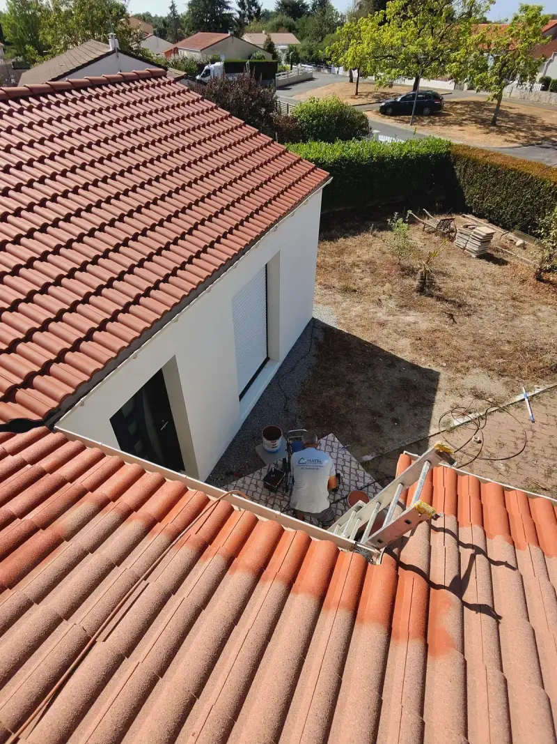 Chantier de peinture de toiture, seaux et échelle depuis le versant